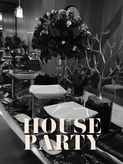 A chic black and white themed house party. The dramatic floral arrangements and high-contrast decor create a modern and stylish atmosphere.