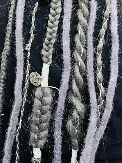 A closer look at the craftsmanship. I mix different textures, including soft wrapped locs and tight braids, and finish the look with custom thread wraps and a small metal charm. Every detail is tailored to create a unique and personal style.