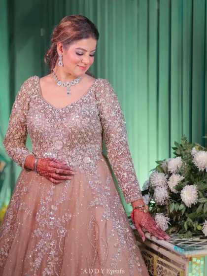 A portrait of the bride in her stunning Sangeet gown, radiating elegance and joy. The decor provides a beautiful, soft-focus backdrop for her moment in the spotlight.