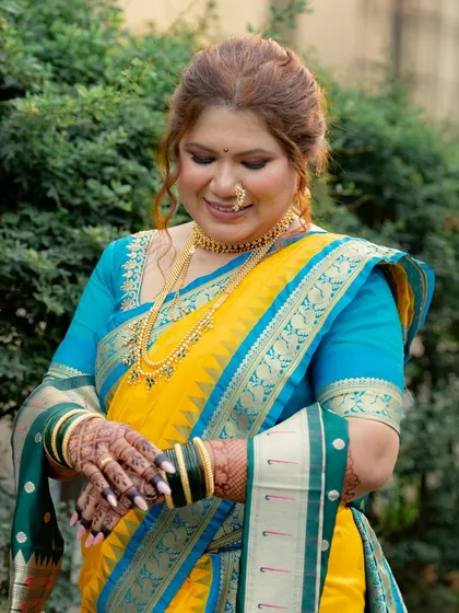 A close-up of the bride's hands, adorned with beautiful henna and traditional bangles, an important part of the Maharashtrian bridal look.