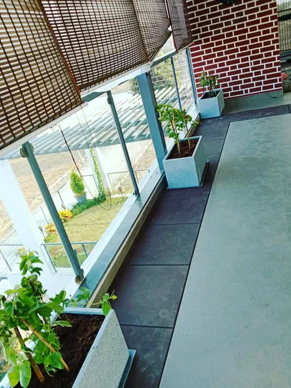 Custom-designed FRP planters lining a glass-paneled balcony, adding greenery without obstructing the view.