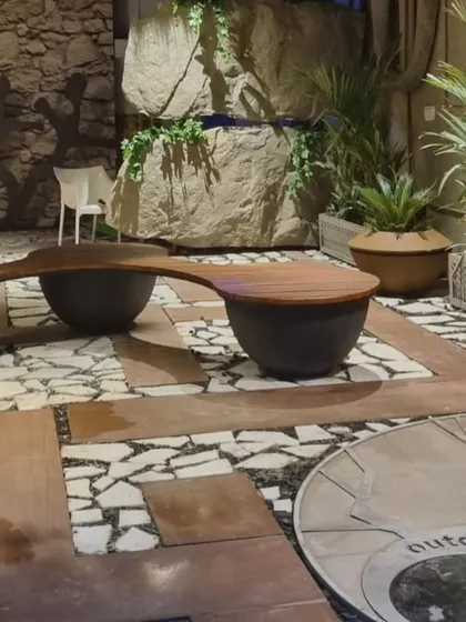 Another view of the unique planter-bench combination, showing its integration with the surrounding rock wall and greenery.