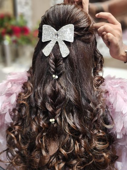 A close-up showing the detail of the braided and curled hairstyle. The pearl accents add a touch of elegance to this modern and trendy look.
