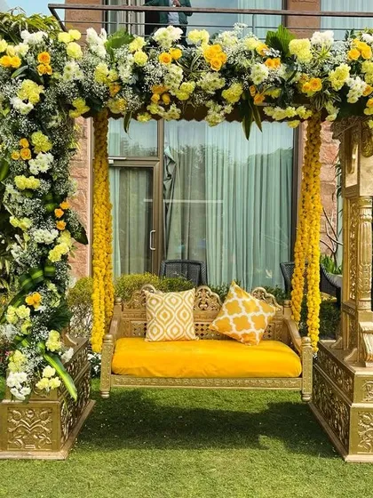 A classic Haldi jhoola (swing) decorated with a mix of yellow and white flowers. This provides a beautiful and traditional seating spot for the bride and groom during the ceremony.
