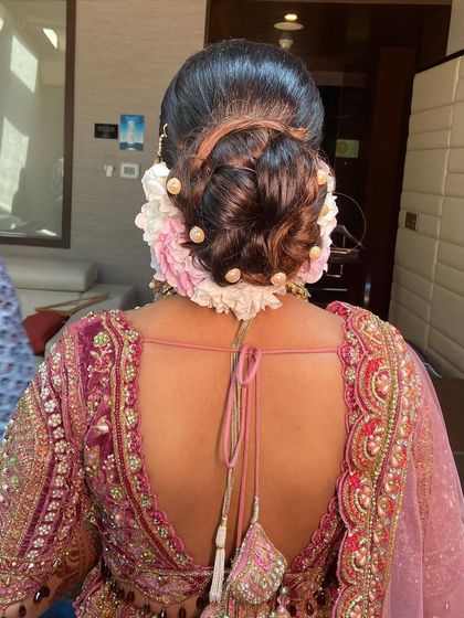 This bridal bun uses a mix of pink and white hydrangeas, dotted with pearls for extra elegance. The combination of flowers and pearls is a personal favorite.