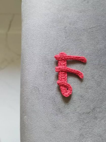 Here is the letter 'F' from my crochet calligraphy applique collection, shown in a bright coral pink.