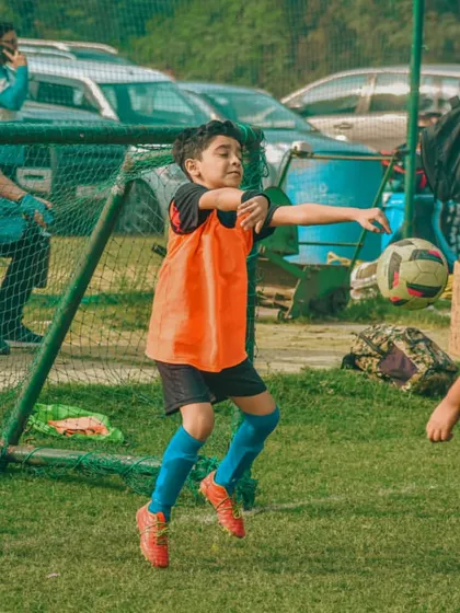 A young goalkeeper throws the ball back into play, starting a new attack for his team.