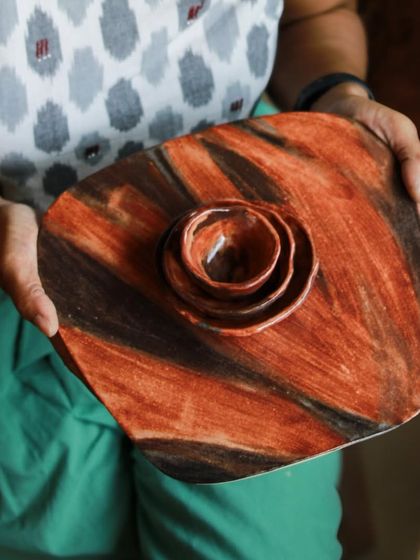 Holding the finished platter to show its scale and beautiful, rustic finish, a result of experimenting with new glaze techniques.
