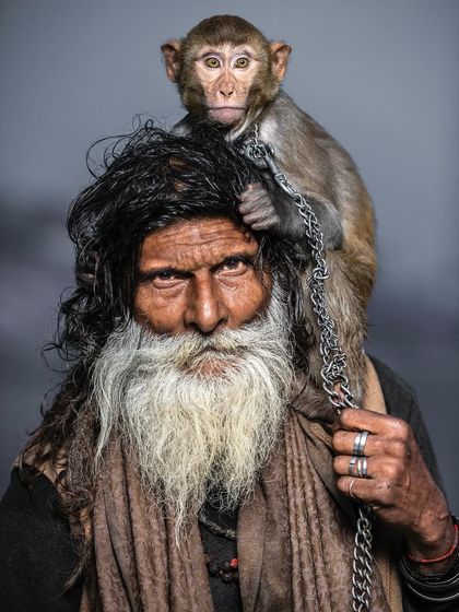 A powerful portrait of Monkey Baba with his companion perched on his shoulder. The intensity in his eyes is matched by the monkey's curious gaze, showing their deep and inseparable connection.