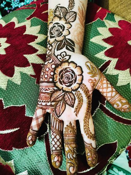 A beautiful floral design with detailed work on the fingers and a central rose motif.