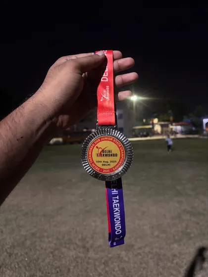 A close-up of a silver medal from a Delhi State Taekwondo event. Every medal is a reminder of the dedication it takes to compete at a high level.