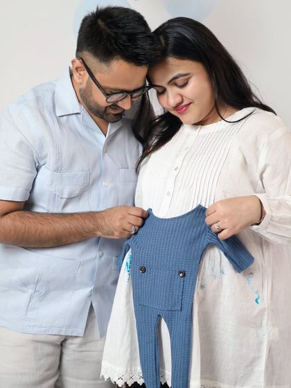 This couple is getting ready for their baby boy with a cute blue outfit. We have a variety of these tiny props to help you make your announcement special.