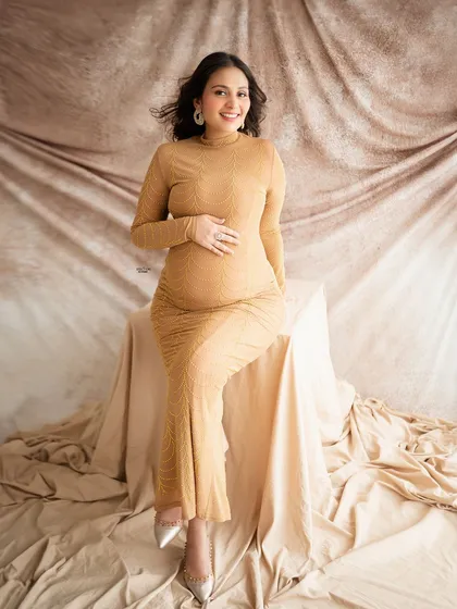 A happy and confident seated portrait. This mamma's smile is infectious, and she looks stunning in this golden-hued bodycon dress.