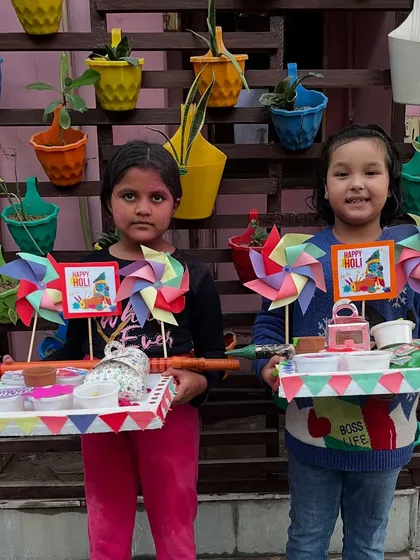 Two friends proudly showing off the matching Holi platters they created together in our workshop.