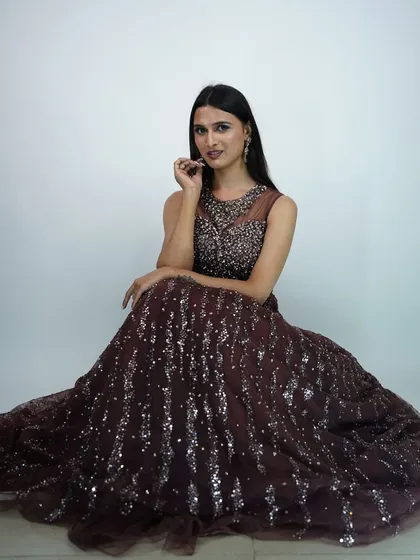 A full seated view of the elegant brown gown, available for rent.