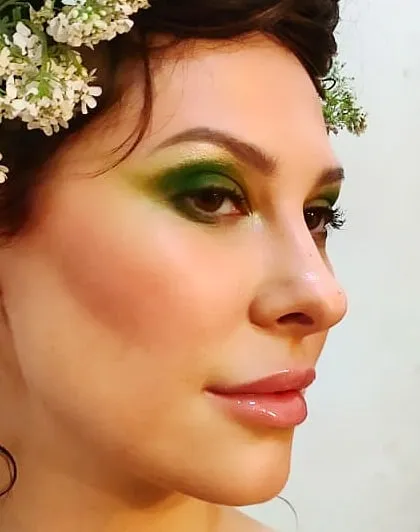 A creative beauty look inspired by nature. I used a vibrant green eyeshadow and glossy lips to create a fresh, ethereal look, complemented by flowers in the hair.