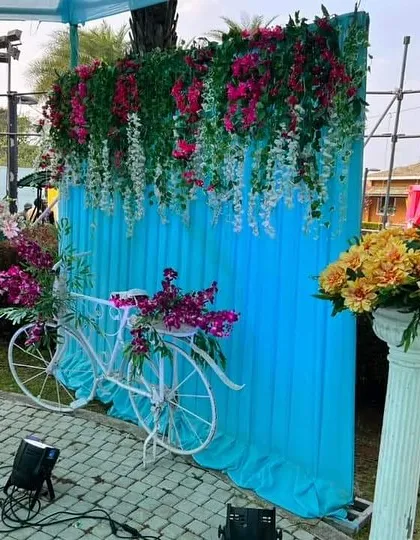 We created this charming photo booth for a Haldi ceremony, featuring a decorative white bicycle adorned with flowers against a bright blue backdrop. It’s a perfect spot for guests to capture fun memories.
