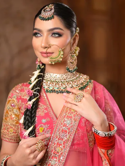 This portrait represents the meeting of grace and grandeur. The makeup features kohl-kissed eyes, a flawless dewy glow, and sharp contouring for a regal bridal statement.
