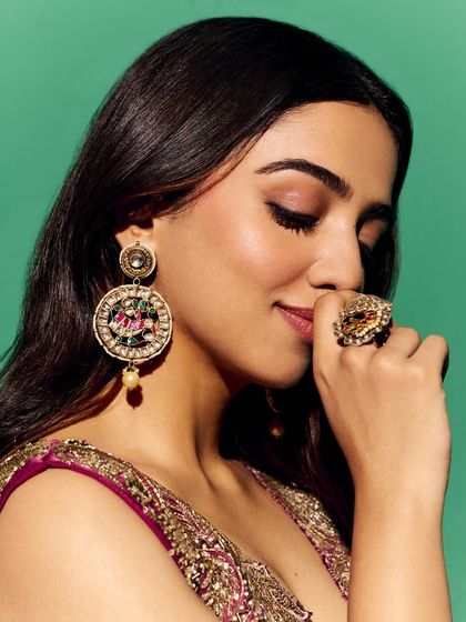 A close-up focusing on the beauty and accessory styling for the Myntra shoot. The makeup, statement ring, and intricate earrings work together to complement the rich tones of the outfit.