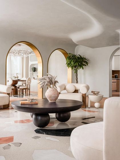The living room of the "Marshmallow" penthouse, where a custom Venetian terrazzo inlay mimics a rug on the seamless microcement floor.
