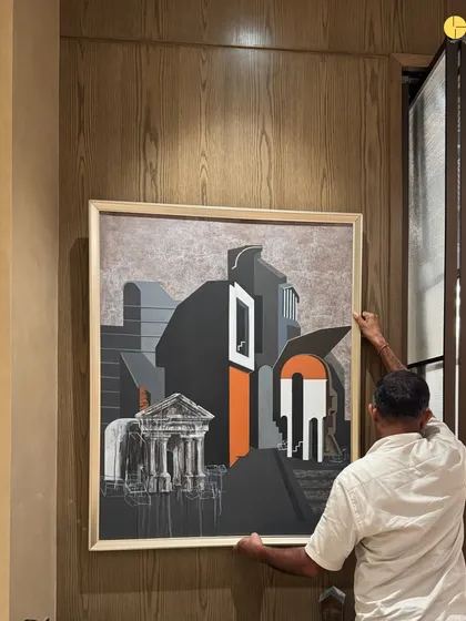 The final layer of design is often the art. A craftsman carefully positions a large painting in a corporate project, a piece that will become a focal point and conversation starter in the new space.