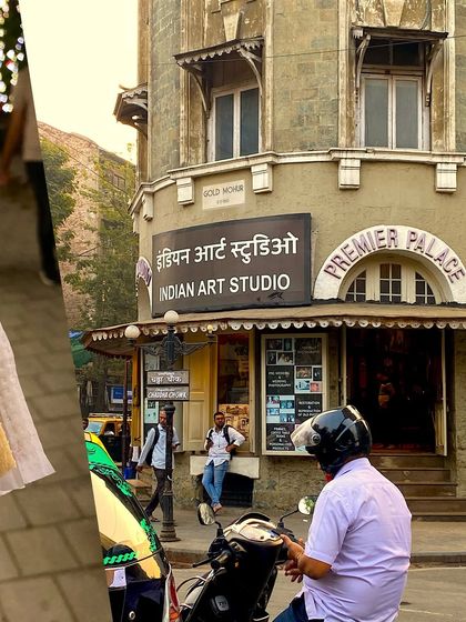A collage capturing the grandeur of the Indian Art Studio in Mumbai, with a scooter parked outside.