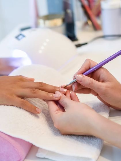 The finishing touch. A delicate brush applies a perfect, even coat of polish, completing this relaxing and beautifying manicure.