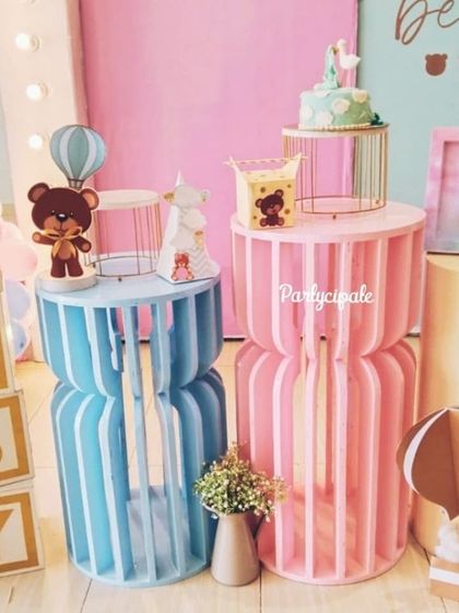 A close-up of the dessert pedestals from the 'We Can Bearly Wait' baby shower. The pink and blue stands are adorned with teddy bear props and miniature hot air balloons.