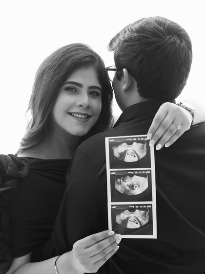 A joyful announcement! This black and white portrait focuses on her happy smile and the sonogram, a perfect way to share their exciting news with the world.