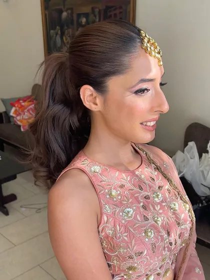 A portrait of the bride-to-be. The high ponytail with a maang tikka is a beautiful and practical choice for a daytime event.