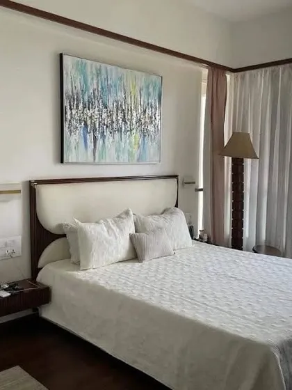 A simple yet elegant bed with a curved, upholstered headboard and floating wooden nightstands. This design is perfect for creating a light and airy feel in a contemporary bedroom.