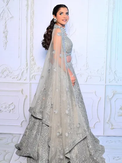 The full-length view shows how a sleek ponytail can perfectly balance a heavily embellished outfit.