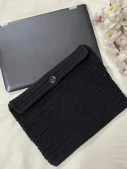 The back of the crochet laptop sleeve, showing the simple and secure button closure that keeps your device safe.