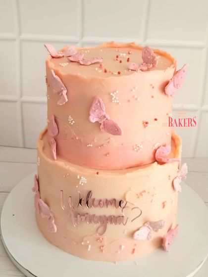 A super cute two-tier cake to welcome baby Ameyaa. This no-fondant cake, decorated with delicate pink butterflies, was a vanilla sponge with chunky pineapple and cream cheese frosting.