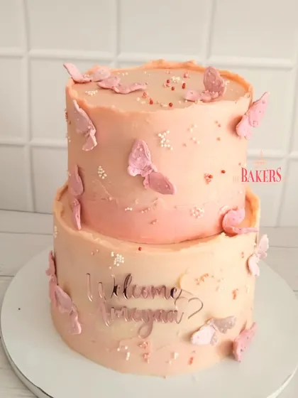 A super cute two-tier cake to welcome baby Ameyaa. This no-fondant cake, decorated with delicate pink butterflies, was a vanilla sponge with chunky pineapple and cream cheese frosting.