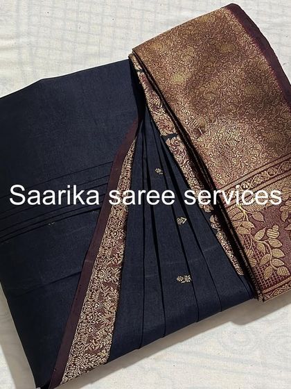 A classic black saree with a gold border. The pleats are perfectly set for a timeless and elegant drape.