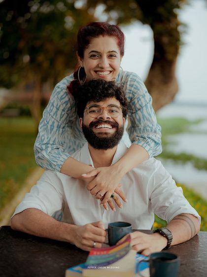 Khushboo and Hari sharing a happy, relaxed moment. Her arms around him from behind create a lovely, affectionate portrait.