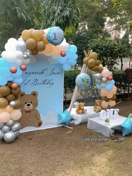 This angle showcases the beautiful pastel and brown balloon arch that frames the personalized teddy bear backdrop, creating a lovely entrance or photo wall for the first birthday party.