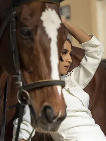 This image captures a gentle moment, with the model stroking the horse. It adds a storytelling element, blending fashion with a narrative of companionship and nature.