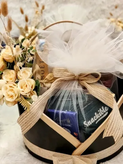 A close-up of a Yes Bank hamper, showcasing the curation of high-end brands like Moët & Chandon and Snackible, all elegantly wrapped in a reusable basket.