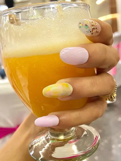Love for pastel shades. This pretty manicure with yellow and pink tones is the perfect accessory for a glass of fresh juice.