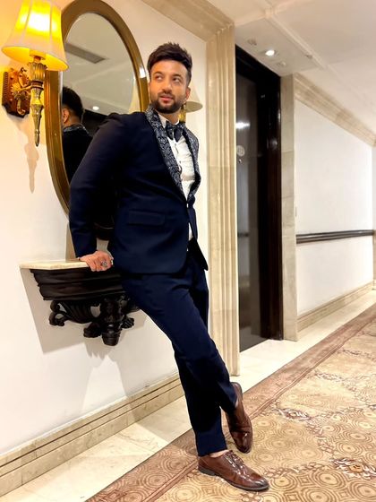 The same navy blue tuxedo, styled in a classic setting. The unique lapel design adds a touch of personality to this elegant look.