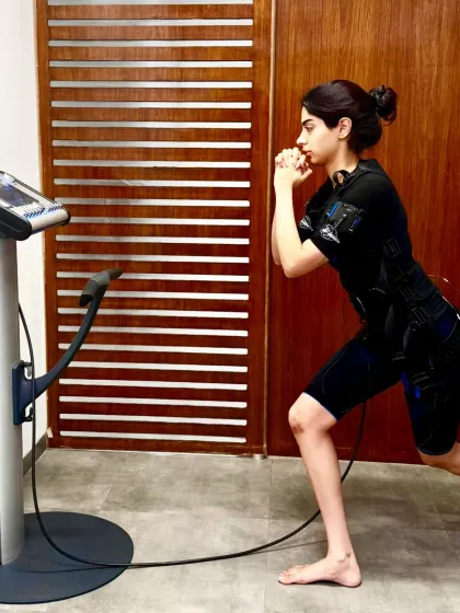 Khushi Kapoor performs a lunge, a fundamental move made incredibly effective by the EMS suit which targets the glutes, quads, and core simultaneously.