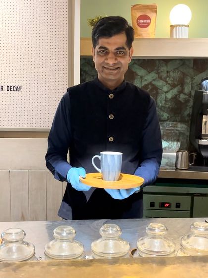 One of our talented baristas, proudly presenting a freshly made cup of coffee.