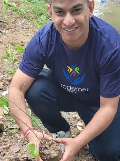 A volunteer from our partner NTT Data smiles as he plants a sapling at Aravali Creek. Their contribution helps enrich the biodiversity of this important green corridor.