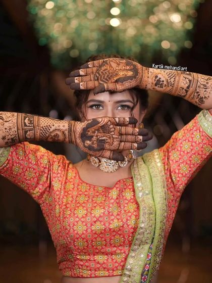 A classic pose with the bride peeking through her mehandi-covered hands.