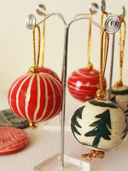 A close-up of the round Christmas baubles on display. I love creating a variety of patterns, from simple stripes to intricate tree motifs, all tied with a golden string.