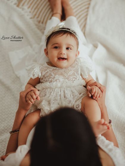 An adorable shot from the mother's perspective, looking down at her happy baby. A unique and personal way to capture their bond.