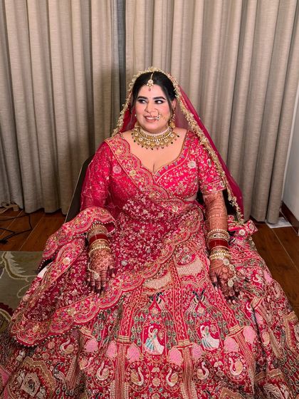 A full-length view of the bride in her magnificent lehenga. The makeup is balanced to complement the grandeur of her attire.