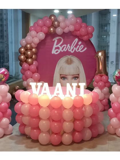 A straight-on view of the Barbie setup, showing the symmetry of the balloon pillars and the central cake display.